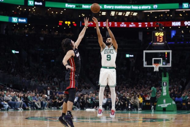 Boston Celtics' Derrick White (9) shoots over Miami Heat's Jaime Jaquez Jr. (11) during the second half of an NBA basketball game, Friday, Oct. 27, 2023, in Boston. 