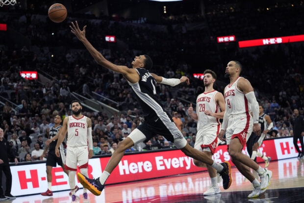 San Antonio Spurs center Victor Wembanyama (1) reaches for a pass during overtime in the team's NBA basketball game against the Houston Rockets in San Antonio, Friday, Oct. 27, 2023.