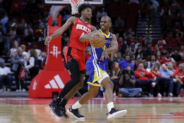 Golden State Warriors guard Chris Paul, right, passes the ball in front of Houston Rockets guard Jalen Green during the second half of an NBA basketball game CP3