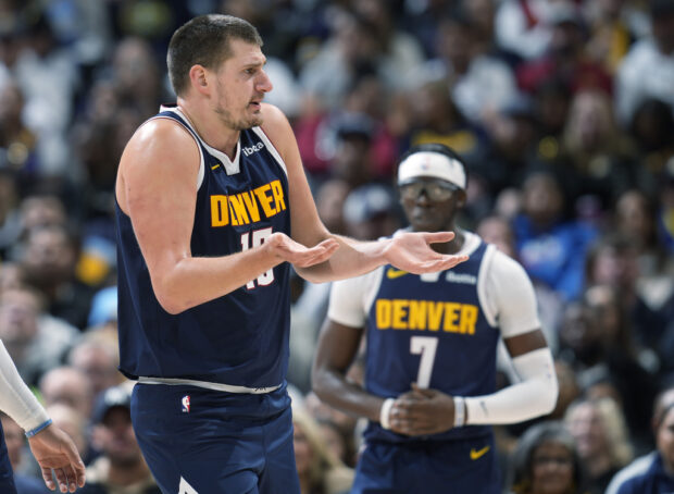 Denver Nuggets center Nikola Jokic, left, argues for a call in the first half of an NBA basketball game against the Utah Jazz,