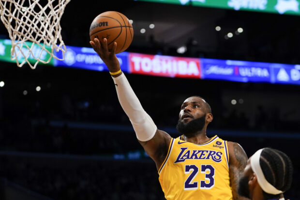 Los Angeles Lakers forward LeBron James lays the ball up during the first half of an NBA basketball game against the Orlando Magic, 