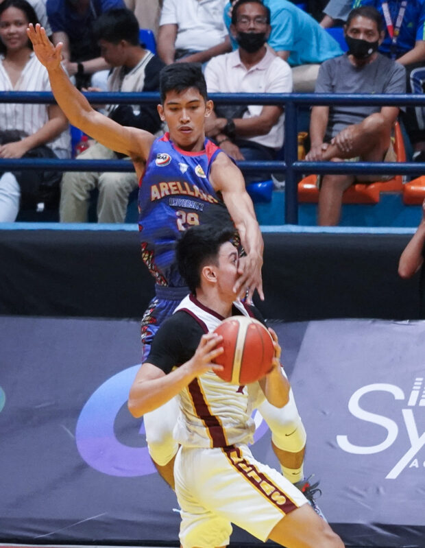 Perpetual’s Jelo Razon (with ball) takes a hard foul from Arellano’s Joshua Abastillas. —AUGUST DELA CRUZ