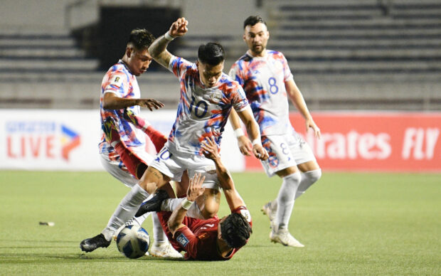 Jose Porteria (C upper) of the Philippines vies for the ball with Vu Van Thanh (C down) of Vietnam during the 2026 World Cup qualifying match between the Philippines and Vietnam in Manila on November 16, 2023.