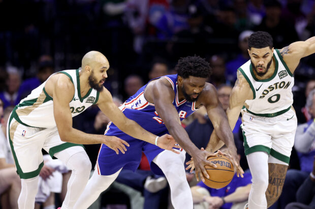 Joel Embiid #21 of the Philadelphia 76ers challenges for the ball with Derrick White #9 and Jayson Tatum #0 of the Boston Celtics during the fourth quarter at the Wells Fargo Center on November 15, 2023 in Philadelphia, Pennsylvania.