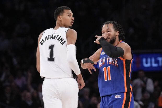 New York Knicks' Jalen Brunson (11), right, reacts after hitting a three-point shot past San Antonio Spurs' Victor Wembanyama during the second half of an NBA basketball game, Wednesday, Nov. 8, 2023, in New York. The Knicks defeated the Spurs 126-105.