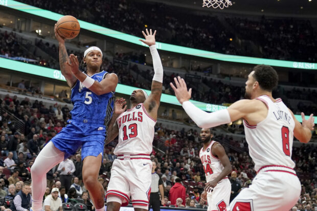 Orlando Magic's Paolo Banchero (5) passes as Chicago Bulls' Torrey Craig (13) and Zach LaVine defend during the first half of an NBA basketball game Wednesday, Nov. 15, 2023, in Chicago.