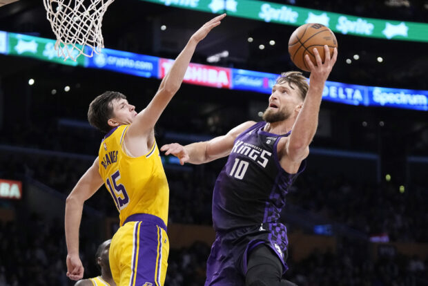 Sacramento Kings forward Domantas Sabonis, right, shoots as Los Angeles Lakers guard Austin Reaves defends during the second half of an NBA basketball game Wednesday, Nov. 15, 2023, in Los Angeles. 