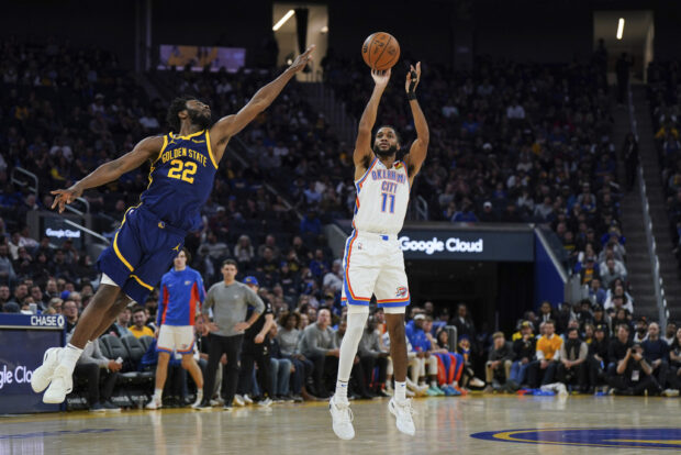 Oklahoma City Thunder guard Isaiah Joe (11) shoots as Golden State Warriors forward Andrew Wiggins (22) defends during the second half of an NBA basketball game Thursday, Nov. 16, 2023, in San Francisco