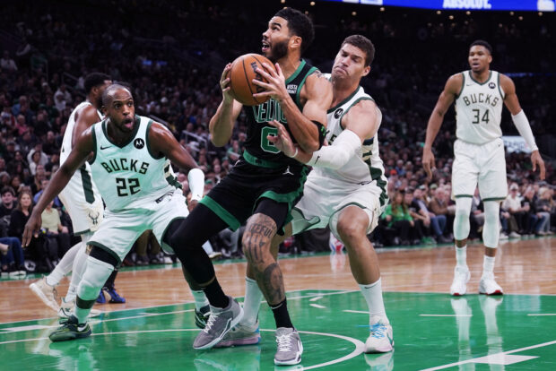 Boston Celtics forward Jayson Tatum drives to the basket against Milwaukee Bucks center Brook Lopez, right, and forward Khris Middleton (22) during the first half of an NBA basketball game, Wednesday, Nov. 22, 2023, in Boston.