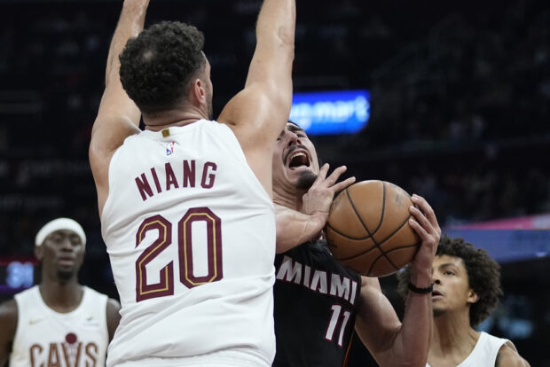 Miami Heat guard Jaime Jaquez Jr. (11) collides with Cleveland Cavaliers forward Georges Niang (20) during the first half of an NBA basketball game Wednesday, Nov. 22, 2023, in Cleveland. 