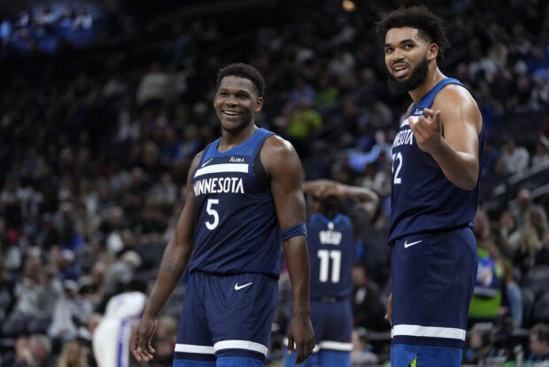Minnesota Timberwolves guard Anthony Edwards (5) and center Karl-Anthony Towns (32) stand on the court during the second half of the team's NBA basketball game against the Philadelphia 76ers, Wednesday, Nov. 22, 2023, in Minneapolis