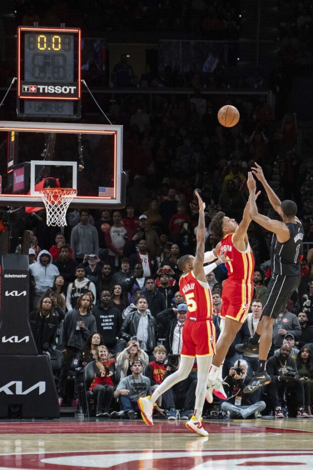 Brooklyn Nets forward Mikal Bridges (1) shoots against Atlanta Hawks forward Jalen Johnson (1) and Dejounte Murray (5) during the second half of an NBA basketball game Wednesday, Nov. 22, 2023, in Atlanta.