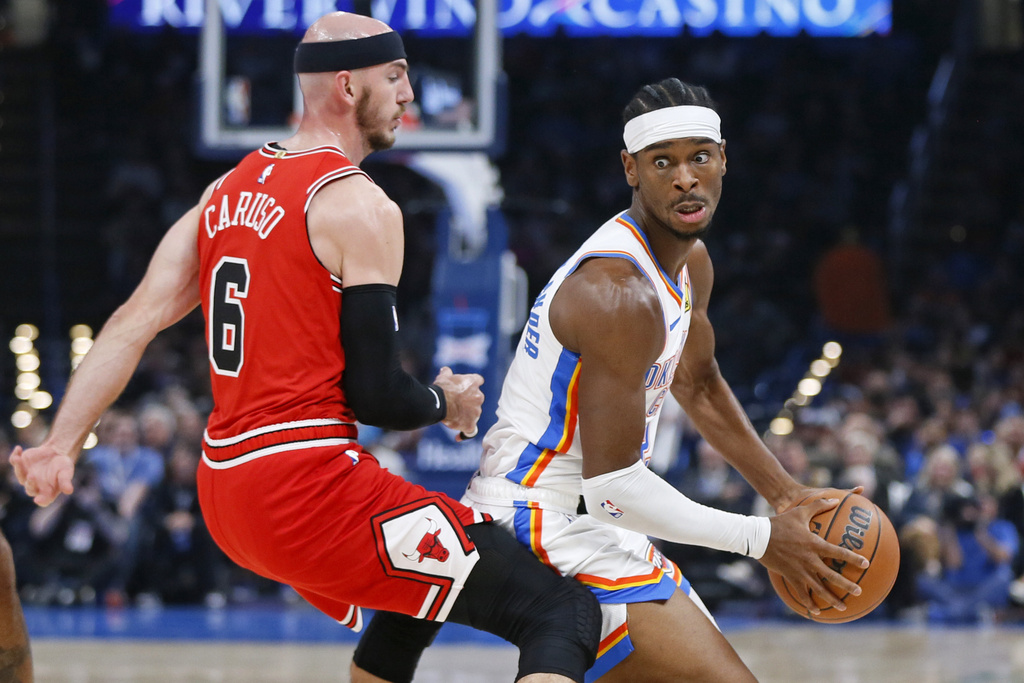 Oklahoma City Thunder guard Shai Gilgeous-Alexander, right, spins around Chicago Bulls guard Alex Caruso (6) during the first half of an NBA basketball game, Wednesday, Nov. 22, 2023, in Oklahoma City.