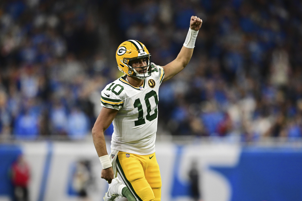 Green Bay Packers quarterback Jordan Love runs up field after throwing a touchdown to wide receiver Christian Watson during the second half of an NFL football game against the Detroit Lions, Thursday, 