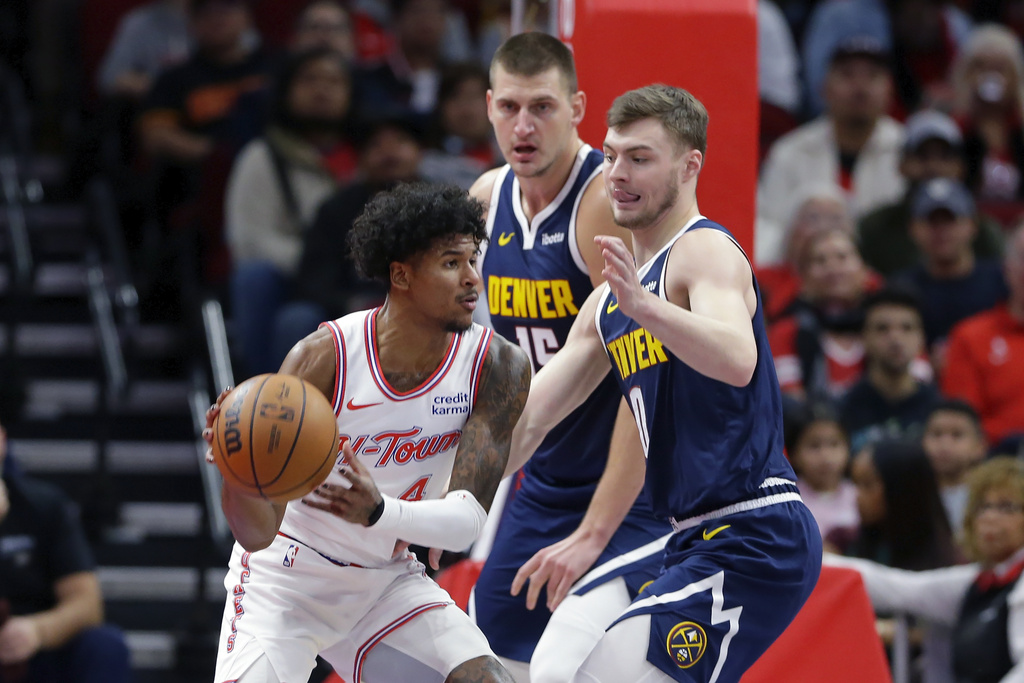 Houston Rockets guard Jalen Green, left, looks to pass the ball under pressure from Denver Nuggets center Nikola Jokic, center, and guard Christian Braun, right, during the first half of an NBA basketball In-Season Tournament game Friday, Nov. 24, 2023, in Houston.