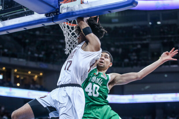 UP rookie Francis Lopez hangs on the rim during Game 1 of the UAAP Season 86 men's basketball Finals against La Salle.–MARLO CUETO/INQUIRER.net