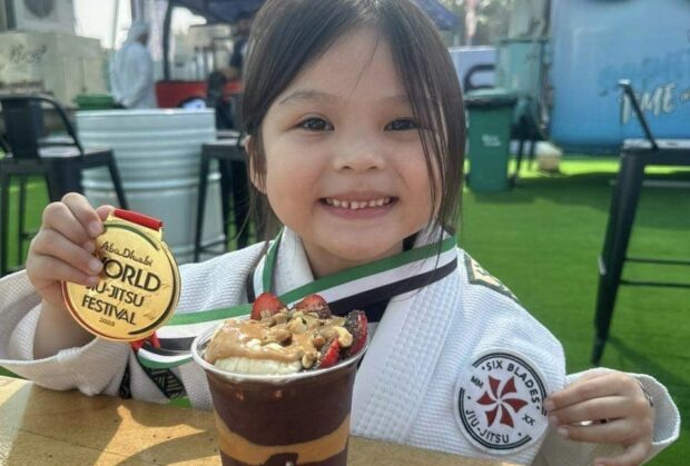 Aleia Aielle Aguilar shows off her medal while enjoying a sweet treat. —CONTRIBUTED PHOTO