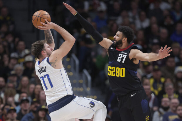 Luka Doncic #77 of the Dallas Mavericks puts up a shot over Jamal Murray #27 of the Denver Nuggets in the third quarter at Ball Arena on December 18, 2023 in Denver, Colorado