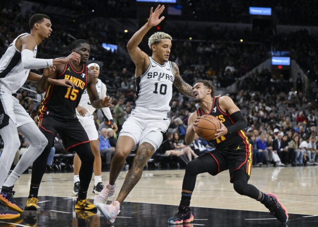 Atlanta Hawks' Trae Young, right, drives against San Antonio Spurs' Jeremy Sochan (10) during the first half of an NBA basketball game Thursday, Nov. 30, 2023, in San Antonio. 