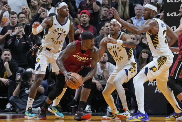 Miami Heat forward Jimmy Butler, second from left, looks for an opening past Indiana Pacers guards Buddy Hield (7) Bruce Brown (11) and center Myles Turner (33) during the second half of an NBA basketball game, Thursday, Nov. 30, 2023, in Miami