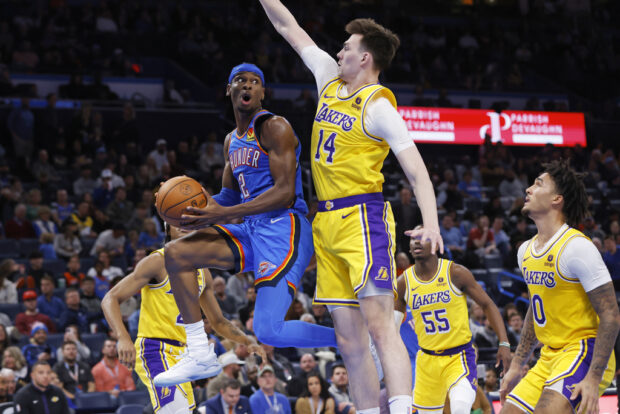 Oklahoma City Thunder guard Shai Gilgeous-Alexander (2) prepares to pass the ball away from Los Angeles Lakers center Colin Castleton (14) as Lakers guard Jalen Hood-Schifino, right, watches during the second half of an NBA basketball game Thursday, Nov. 30, 2023, in Oklahoma City. 
