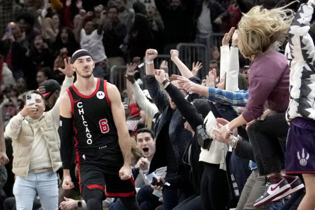 Chicago Bulls' Alex Caruso celebrates with fans after his 3-point basket at the buzzer in regulation sent the NBA basketball game against the Milwaukee Bucks into overtime Thursday, Nov. 30, 2023, in Chicago