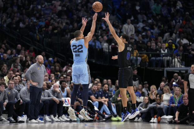Memphis Grizzlies guard Desmond Bane (22) shoots and sinks a three-point basket over the top of Dallas Mavericks guard Josh Green (8) in the second half of an NBA basketball game in Dallas, Friday, Dec. 1, 2023. 