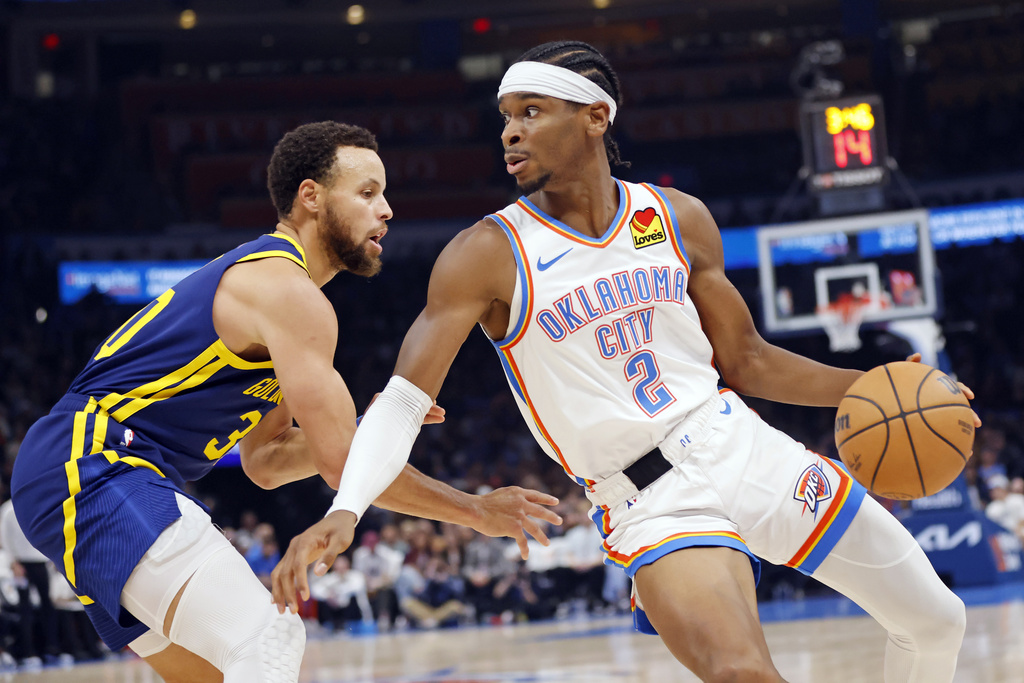 Oklahoma City Thunder guard Shai Gilgeous-Alexander (2) spins around Golden State Warriors guard Stephen Curry during the first half of an NBA basketball game Friday, Dec. 8, 2023, in Oklahoma City.