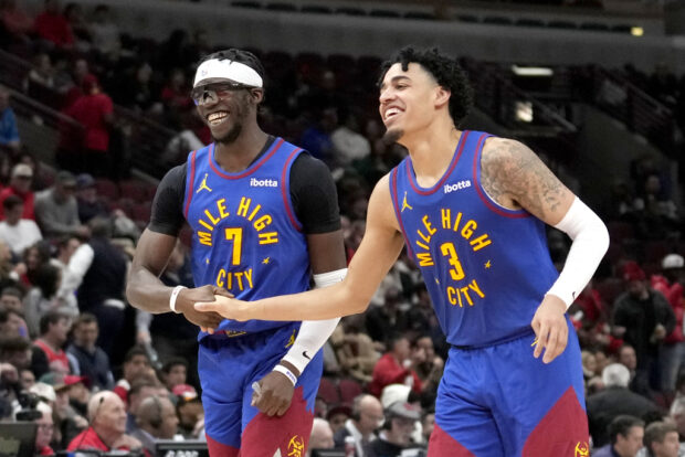 Denver Nuggets guard Reggie Jackson (7) and guard Julian Strawther begin to celebrate the team's 114-106 win over the Chicago Bulls late in the second half of an NBA basketball game Tuesday, Dec. 12, 2023, in Chicago.