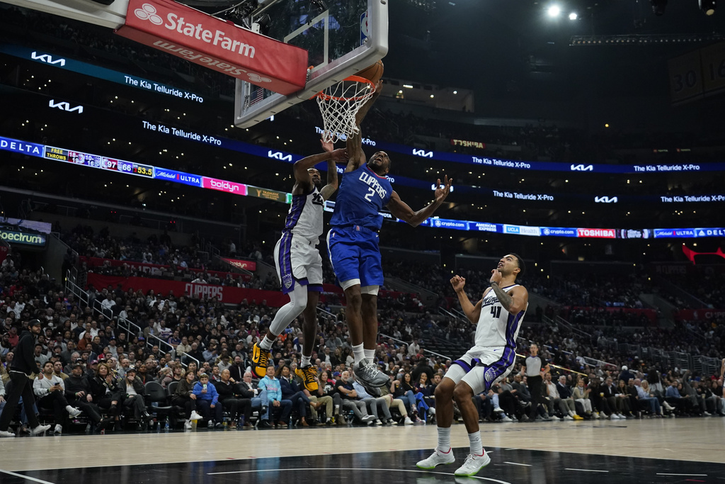 Los Angeles Clippers forward Kawhi Leonard (2) dunks against Sacramento Kings guard Malik Monk (0) during the second half of an NBA basketball game in Los Angeles, Tuesday, Dec. 12, 2023. 