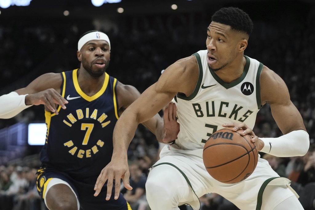 Milwaukee Bucks' Giannis Antetokounmpo drives past Indiana Pacers' Buddy Hield during the first half of an NBA basketball game Wednesday, Dec. 13, 2023, in Milwaukee.