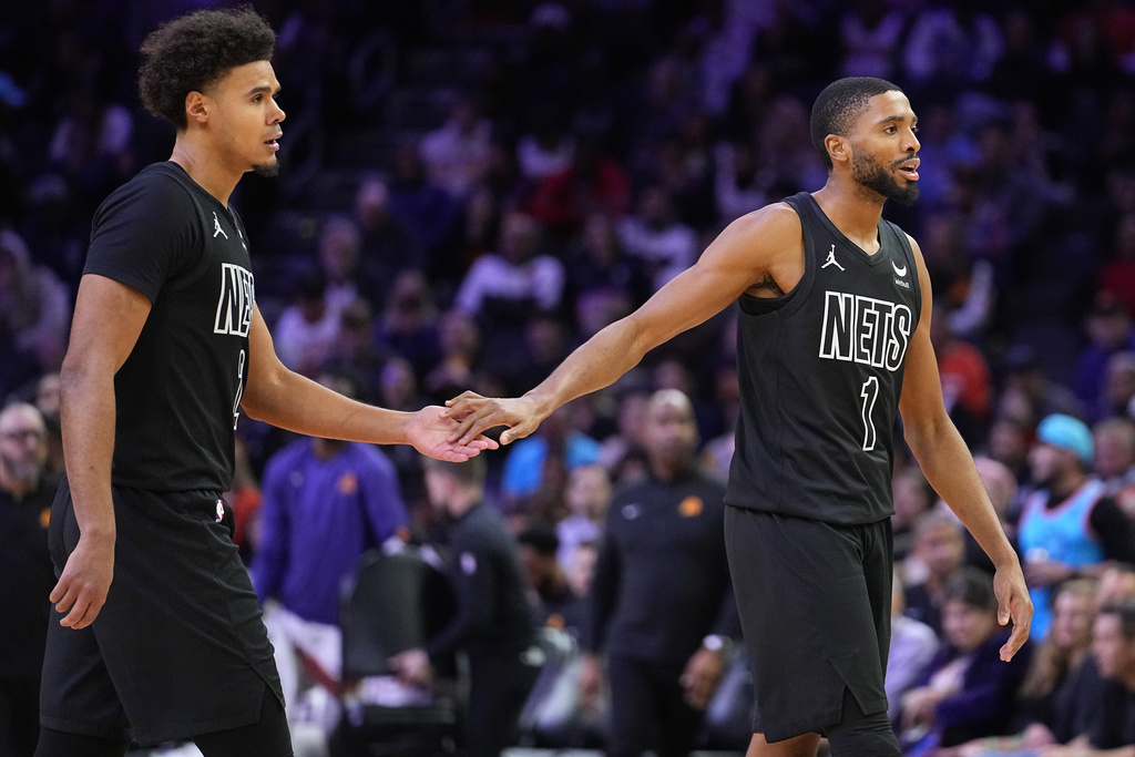 Brooklyn Nets forward Mikal Bridges (1) and orward Cameron Johnson (2) celebrate during a time out during the second half of an NBA basketball game against the Phoenix Suns, Wednesday, Dec. 13, 2023, in Phoenix.
