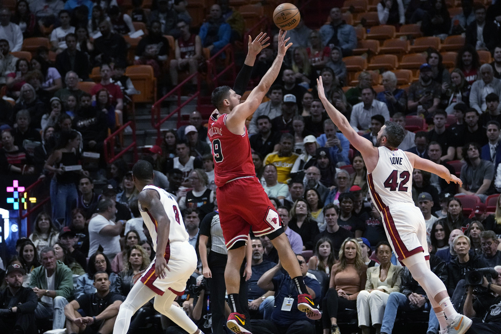 Chicago Bulls center Nikola Vucevic (9) shoots over Miami Heat forward Kevin Love (42) during the first half of an NBA basketball game Thursday, Dec. 14, 2023, in Miami.