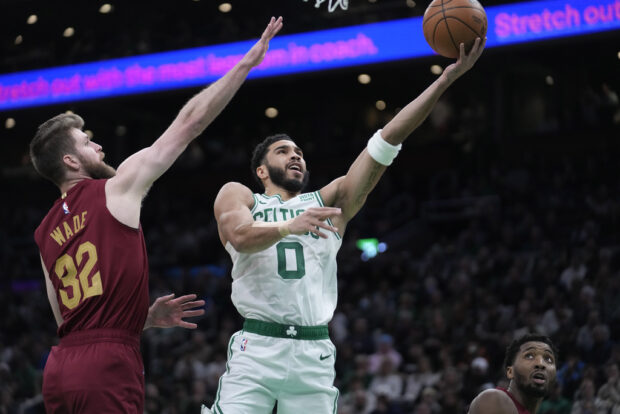 Boston Celtics forward Jayson Tatum (0)shoots at the basket as Cleveland Cavaliers forward Dean Wade (32) defends in the first half of an NBA basketball game, Thursday, Dec. 14, 2023, in Boston