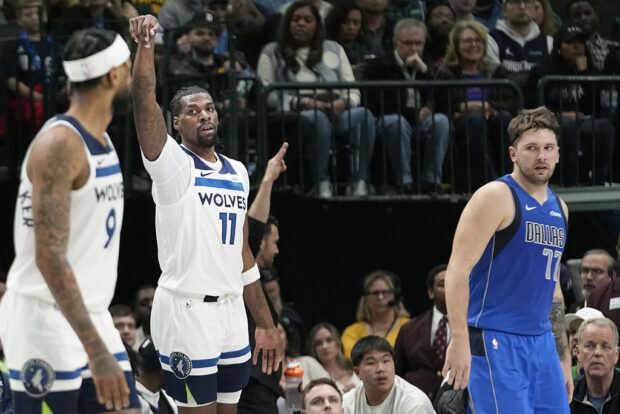Minnesota Timberwolves center Naz Reid (11) reacts after hitting a 3-point basket as Dallas Mavericks guard Luka Doncic (77) looks on during the first half of an NBA basketball game in Dallas, Thursday, Dec. 14, 2023. (