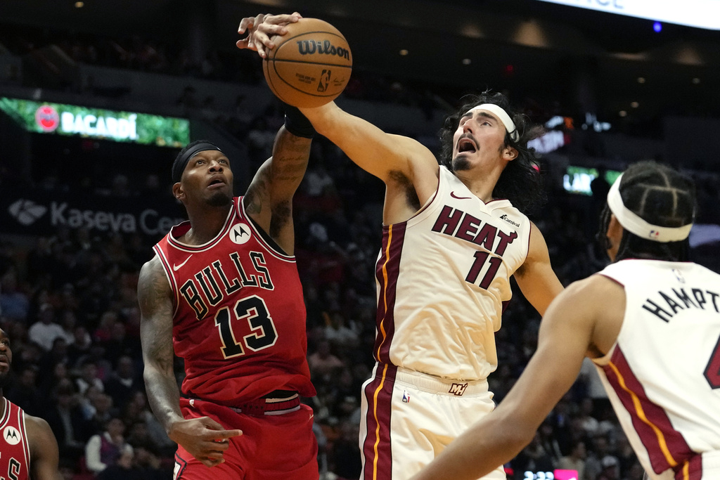Chicago Bulls forward Torrey Craig (13) and Miami Heat guard Jaime Jaquez Jr. (11) go for the ball during the second half of an NBA basketball game, Thursday, Dec. 14, 2023, in Miami.