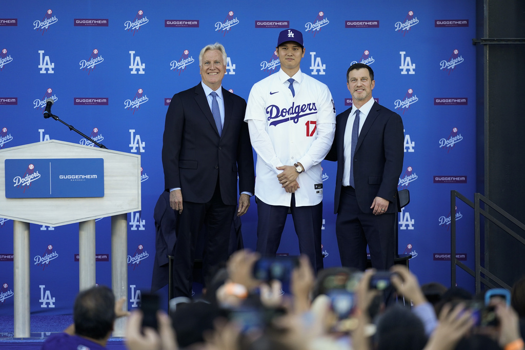 htani, center, poses for a photo with owner and chairman Mark Walter, left, and president of baseball operations Andrew Friedman applaud during a news conference at Dodger Stadium Thursday, Dec. 14, 2023, in Los Angeles. (