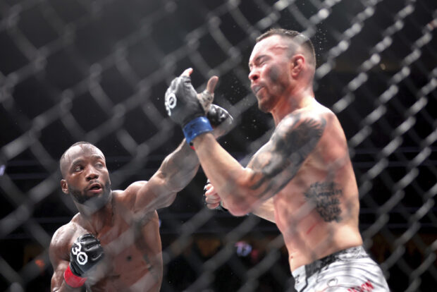 UFC welterweight champion Leon Edwards, left, connects with a punch on Colby Covington during the UFC 296 mixed martial arts event Saturday, Dec. 16, 2023, in Las Vegas. 
