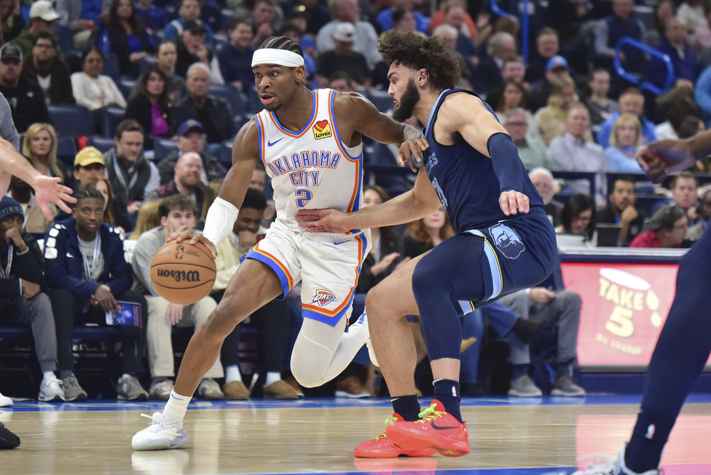 Oklahoma City Thunder guard Shai Gilgeous-Alexander, left, pushes past Memphis Grizzles forward David Roddy in the first half of an NBA basketball game, Monday, Dec. 18, 2023, in Oklahoma City.