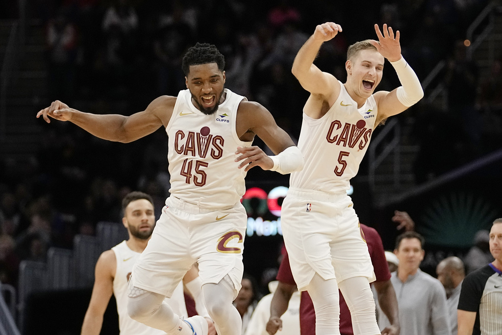 Cleveland Cavaliers guards Donovan Mitchell (45) and Sam Merrill (5) celebrate after a 3-point basket by Merrill in overtime of an NBA basketball game against the Houston Rockets, Monday, Dec. 18, 2023, in Cleveland.