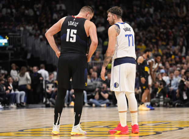 Denver Nuggets center Nikola Jokic (15) and Dallas Mavericks guard Luka Doncic (77) talk during the second quarter of an NBA basketball game Monday, Dec. 18, 2023, in Denver.