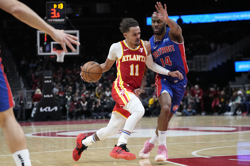 Atlanta Hawks guard Trae Young (11) drives against Detroit Pistons guard Alec Burks (14) during the second half of an NBA basketball game Monday, Dec. 18, 2023, in Atlanta.
