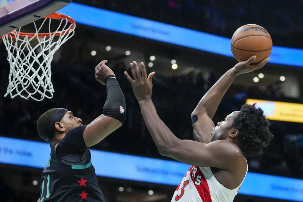 Toronto Raptors forward O.G. Anunoby, right, shoots over Washington Wizards center Daniel Gafford during the first half of an NBA basketball game Wednesday, Dec. 27, 2023, in Washington