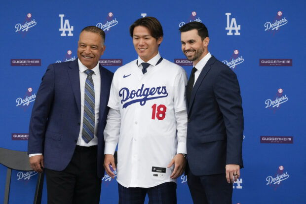 Yoshinobu Yamamoto, center, poses for a photo with manager Dave Roberts, left, and Executive Vice President and General Manager Brandon Gomes during his introduction as a new member of the Los Angeles Dodgers baseball team Wednesday, Dec. 27, 2023, in Los Angeles. 