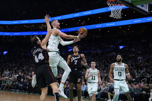 Boston Celtics center Kristaps Porzingis drives to the basket against the Detroit Pistons during the second half of an NBA basketball game, Thursday, Dec. 28, 2023, in Boston.