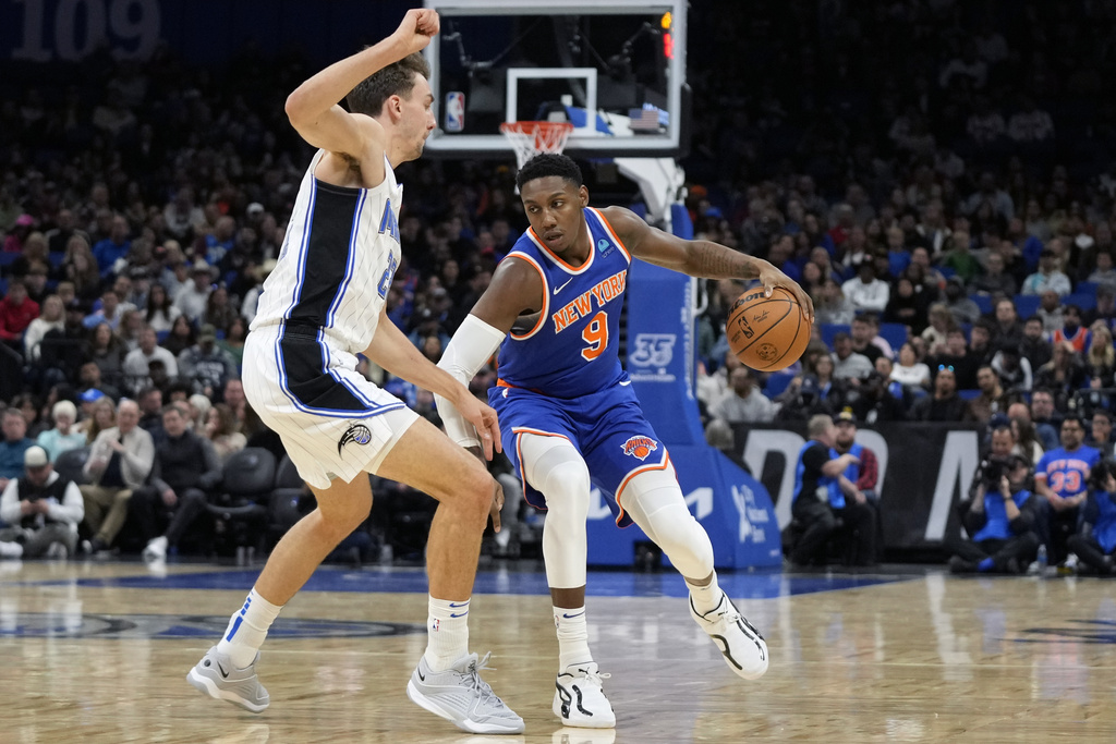 New York Knicks guard RJ Barrett (9) looks for a way around Orlando Magic forward Franz Wagner, left, during the first half of an NBA basketball game, Friday, Dec. 29, 2023, in Orlando, Florida
