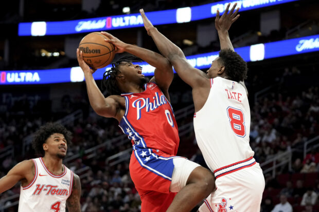 Philadelphia 76ers guard Tyrese Maxey (0) drives to the basket as Houston Rockets forward Jae'Sean Tate (8) defends during the first half of an NBA basketball game Friday, Dec. 29, 2023, in Houston. 