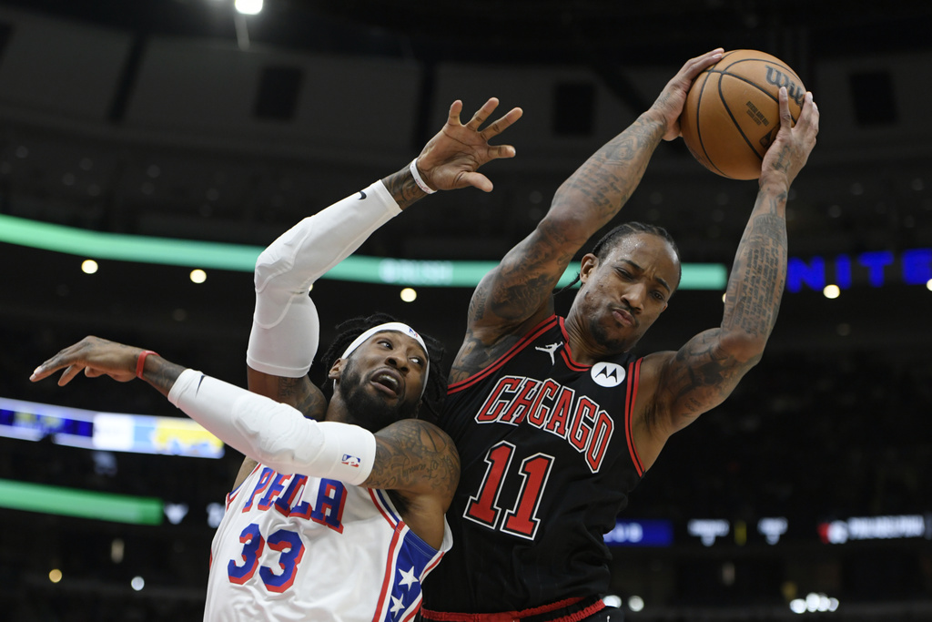 Chicago Bulls' DeMar DeRozan (11) battles Philadelphia 76ers' Robert Covington (33) for a rebound during the first half of an NBA basketball game Saturday, Dec. 30, 2023, in Chicago.