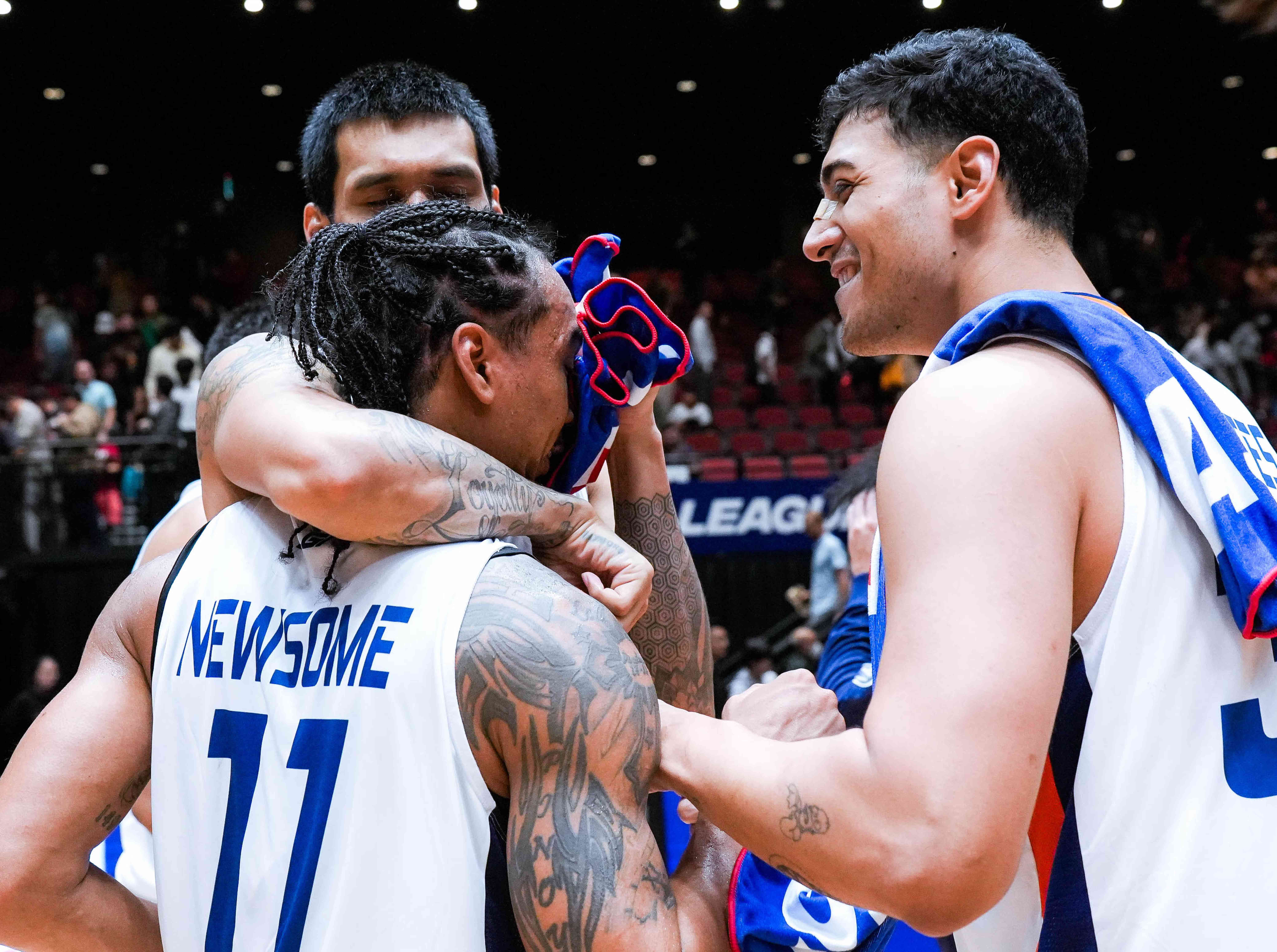 Chris Newsome (No. 11) ismobbed by teammates after his heroics in Meralco’s victory over Ryukyu in Macau. 