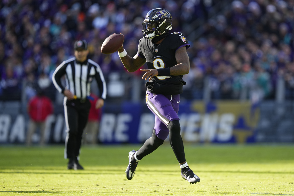 Baltimore Ravens quarterback Lamar Jackson (8) looks to pass as he scrambles against the Miami Dolphins during the first half of an NFL football game in Baltimore, Sunday, Dec. 31, 2023. 